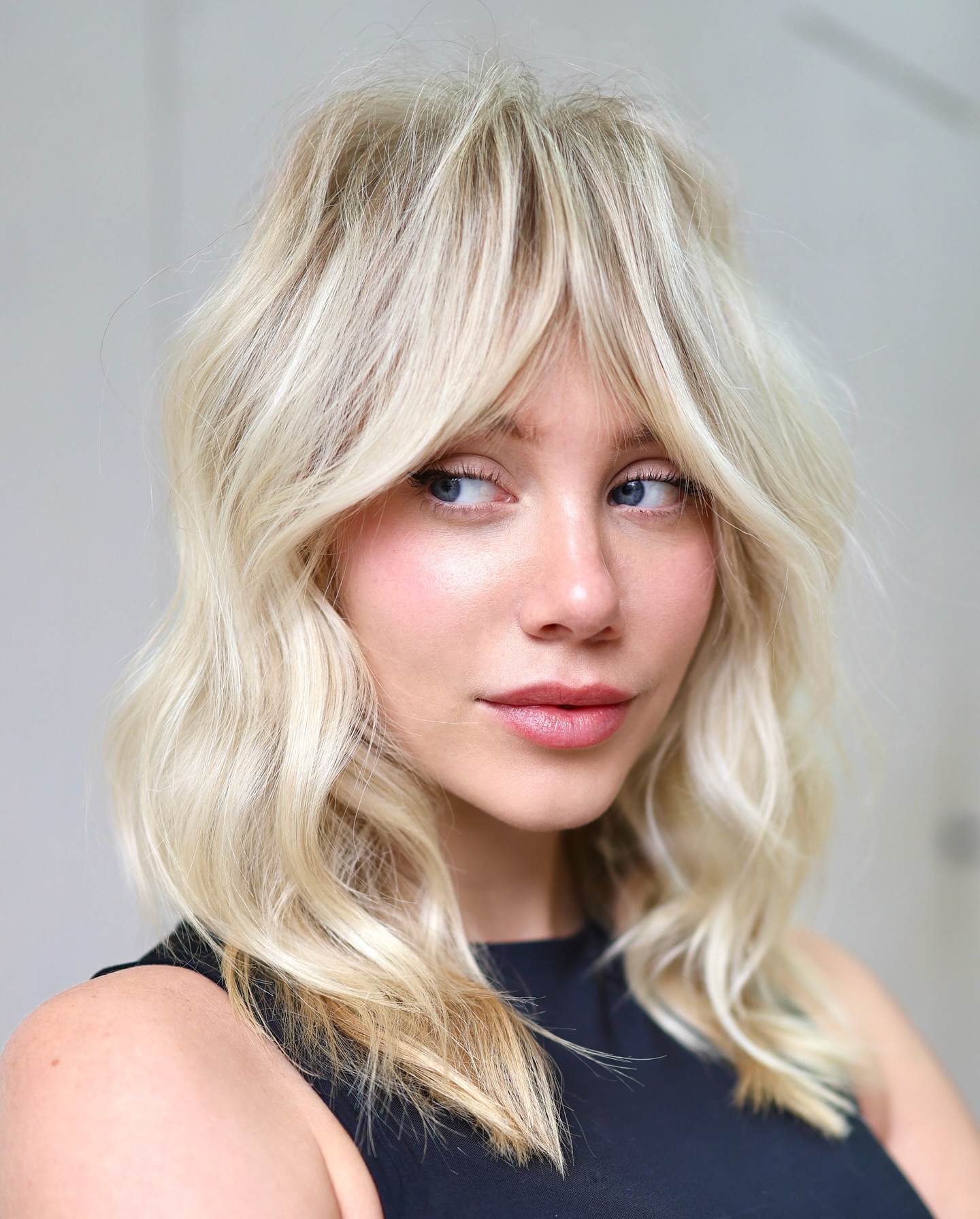 4. Tousled Platinum Waves with Fringe - Medium-Length Hairstyle Ideas for Women