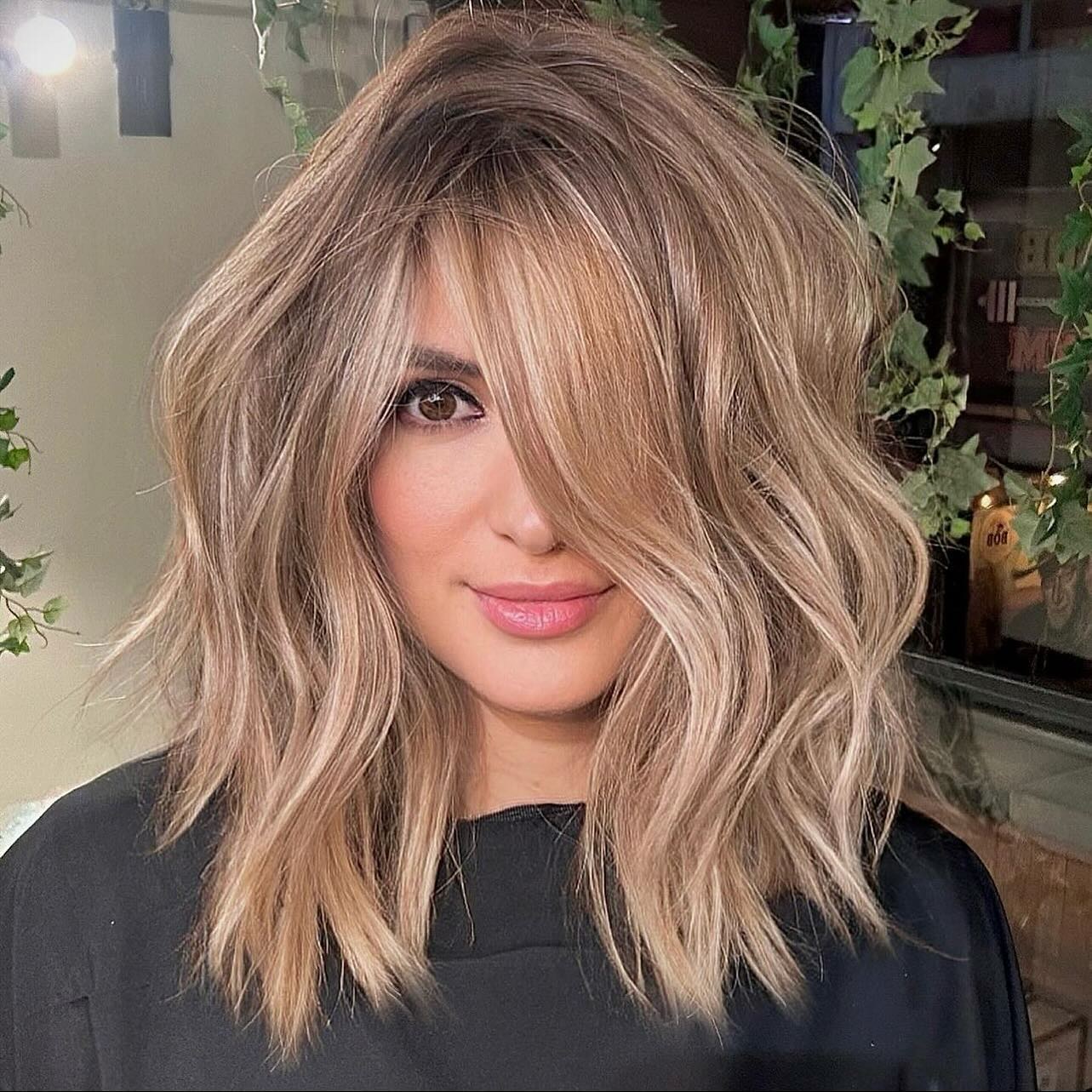 16. Ashy Blonde Balayage with Side-Swept Volume - Medium-Length Hairstyle Ideas for Women